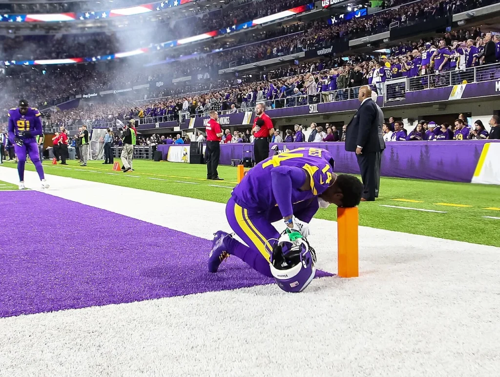 Stefon Diggs kneeling in prayer at the goalpost during his Minnesota Vikings career