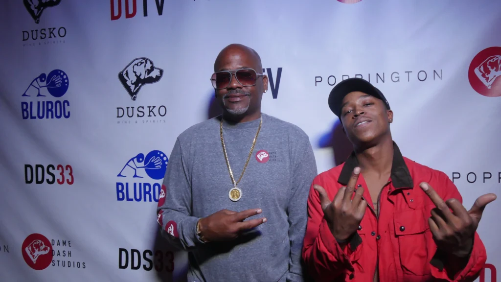 Dame Dash at DDS33 event wearing sunglasses and gold chain