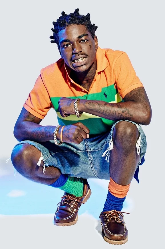Kodak Black in orange and green striped polo shirt