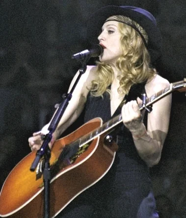 Madonna performing live with acoustic guitar on tour
