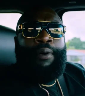 Rick Ross wearing gold sunglasses
