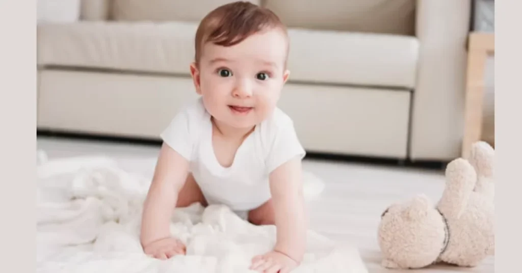 Nine-month-old baby in white onesie crawling on floor with teddy bear, practicing new mobility skills that contribute to 9 month sleep regression