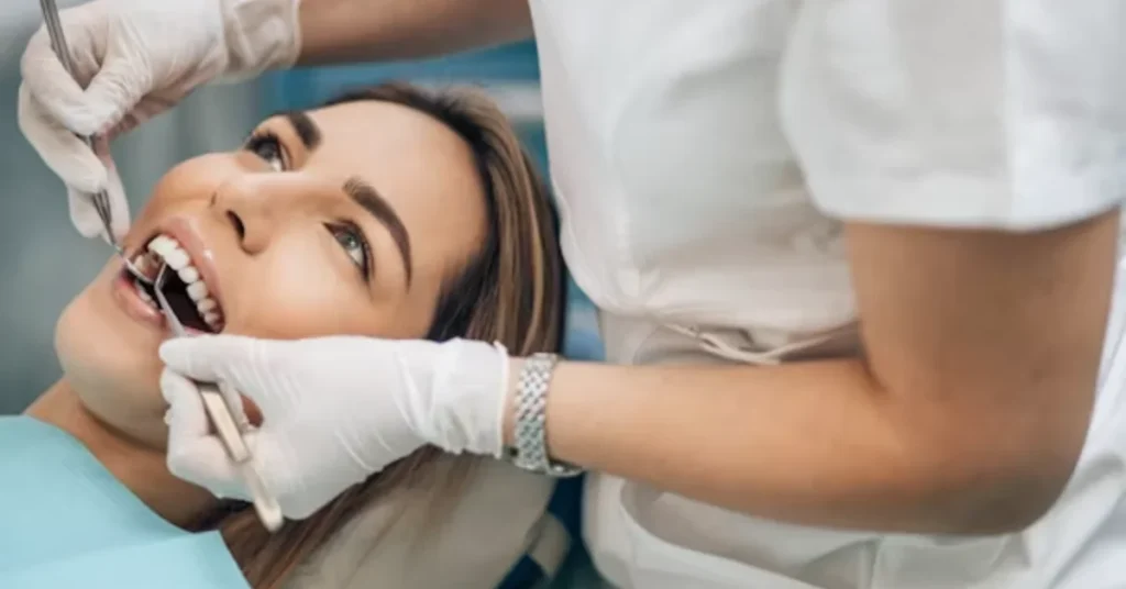 Dental patient receiving an oral examination from a dentist wearing gloves.