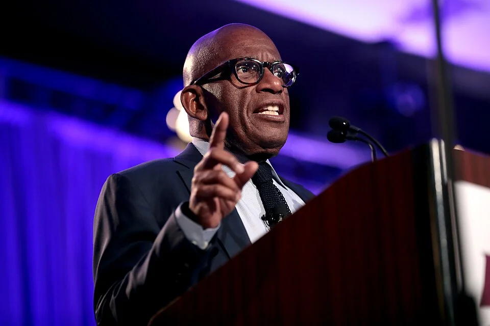 Al Roker speaking at a podium during a live event