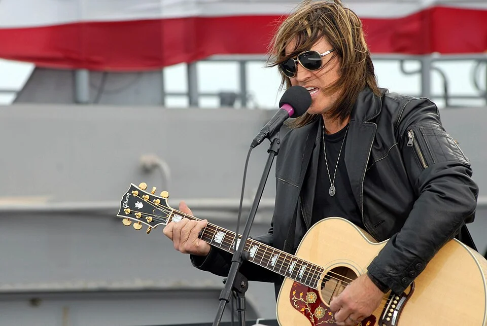 Billy Ray Cyrus performing live with an acoustic guitar