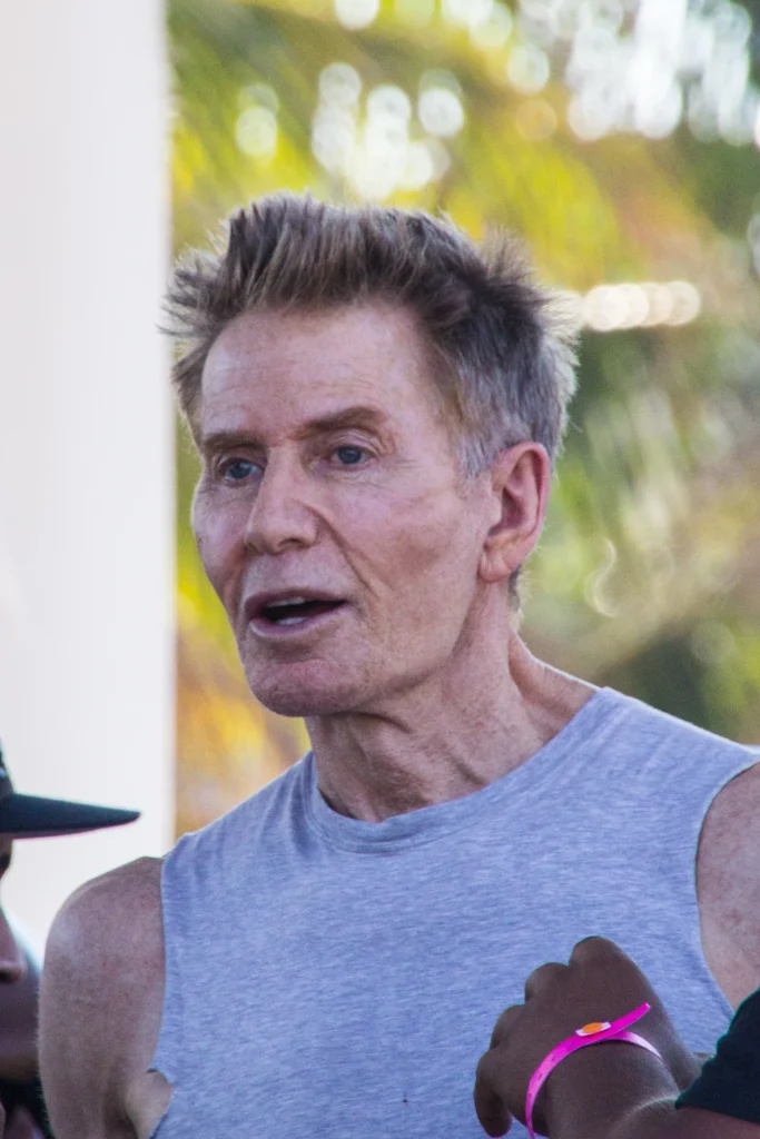 Calvin Klein at outdoor charity event wearing gray tank top