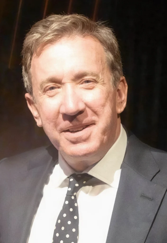Tim Allen smiling in a suit and tie