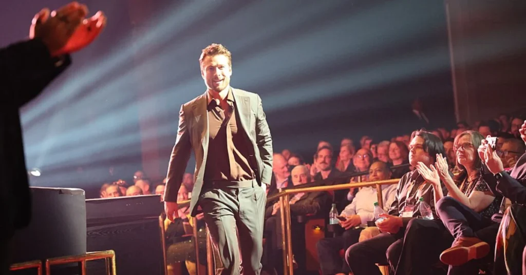 Glen Powell walking on stage, star of Chad Powers season 2