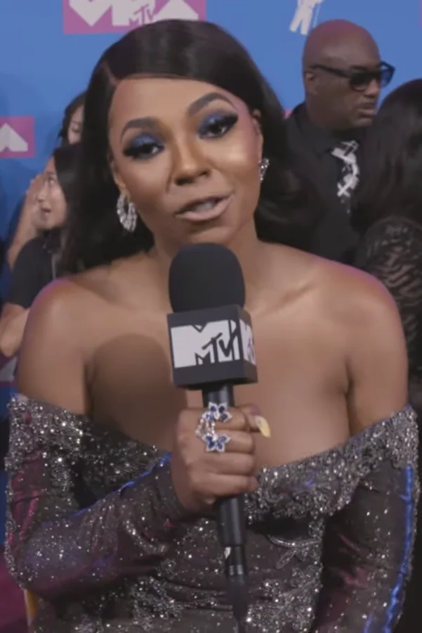 Ashanti holding an MTV microphone during a red carpet interview.